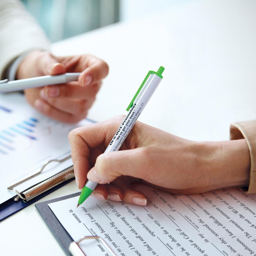 hands holding pens over forms on clipboards.