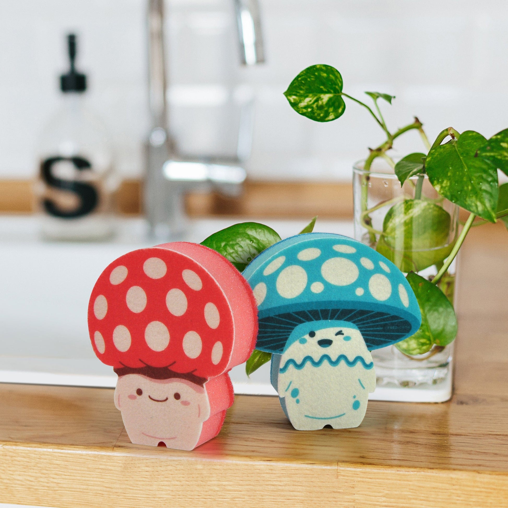 red and blue mushroom shaped sponges displayed with a kitchen sink in the background