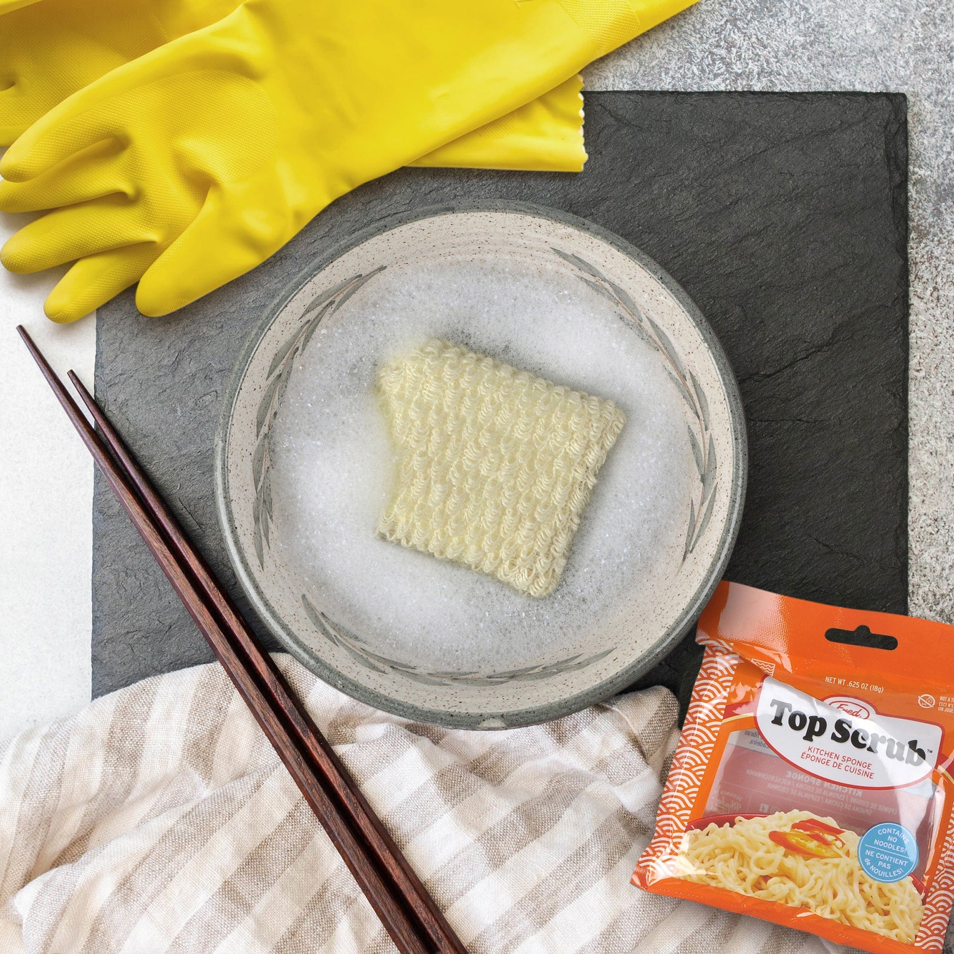 sponge that looks like ramen in a bowl of soapy water.