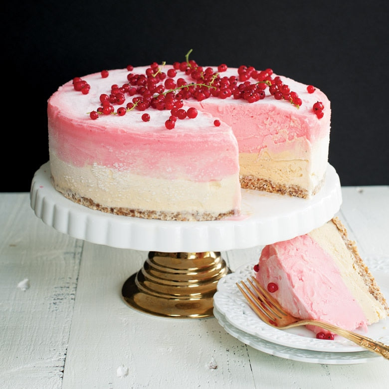 cheesecake on pedestal with slice on plate.