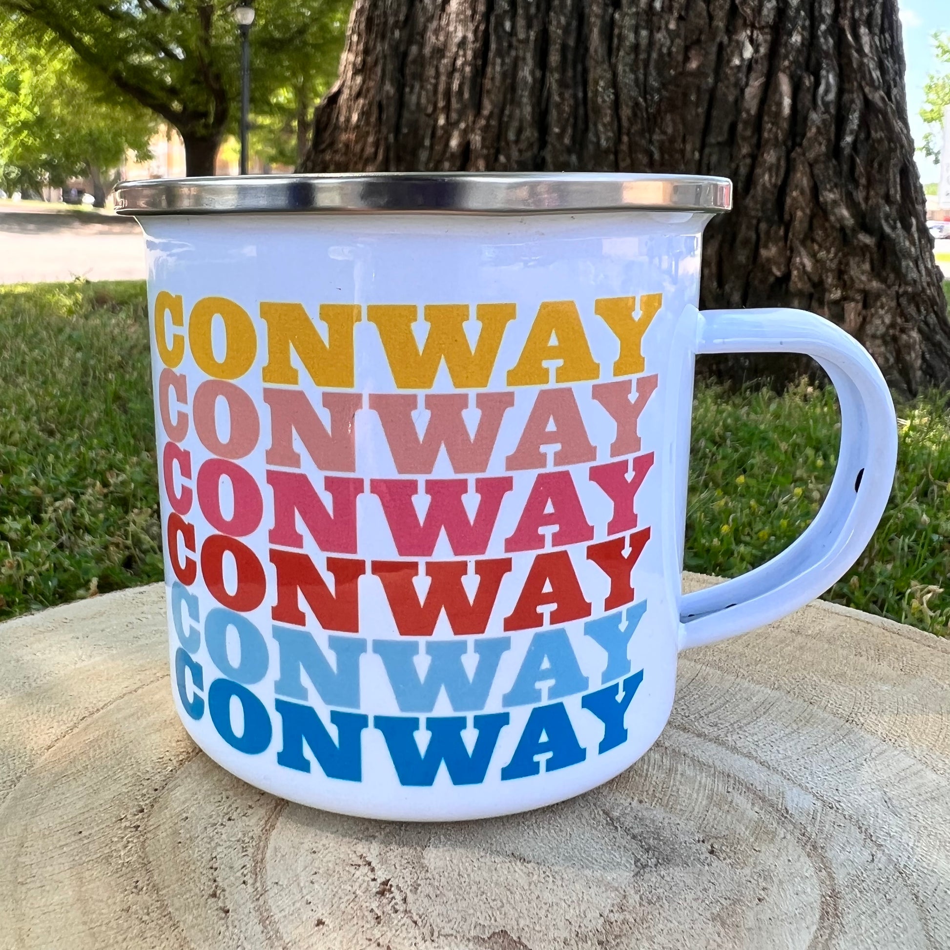 tin mug with "conway" written six times in rainbow colors.