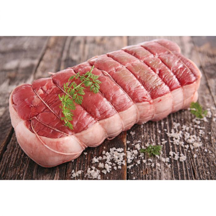 a displayed cut of meat tied with cooking twine on a wooden surface against a white background