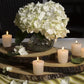three sizes of the acacia wood slab boards displayed with a flower arrangement and candles on a green striped tablecloth