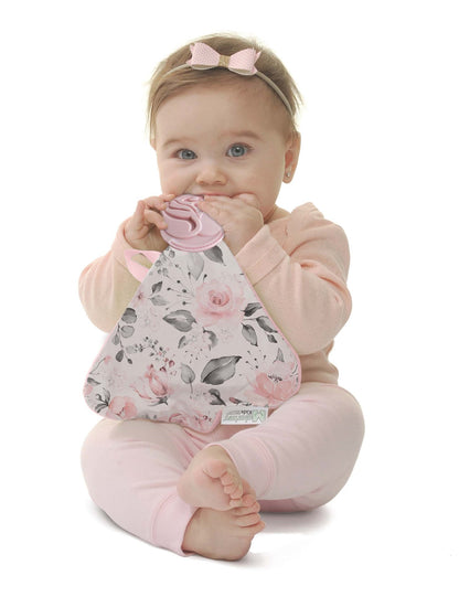 a little girl chewing on the rosie posie munch it blanket against a white background