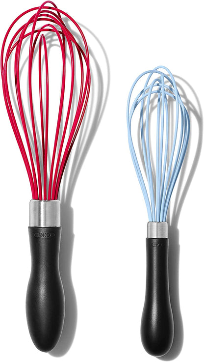 small and large silicone whisks on white background.