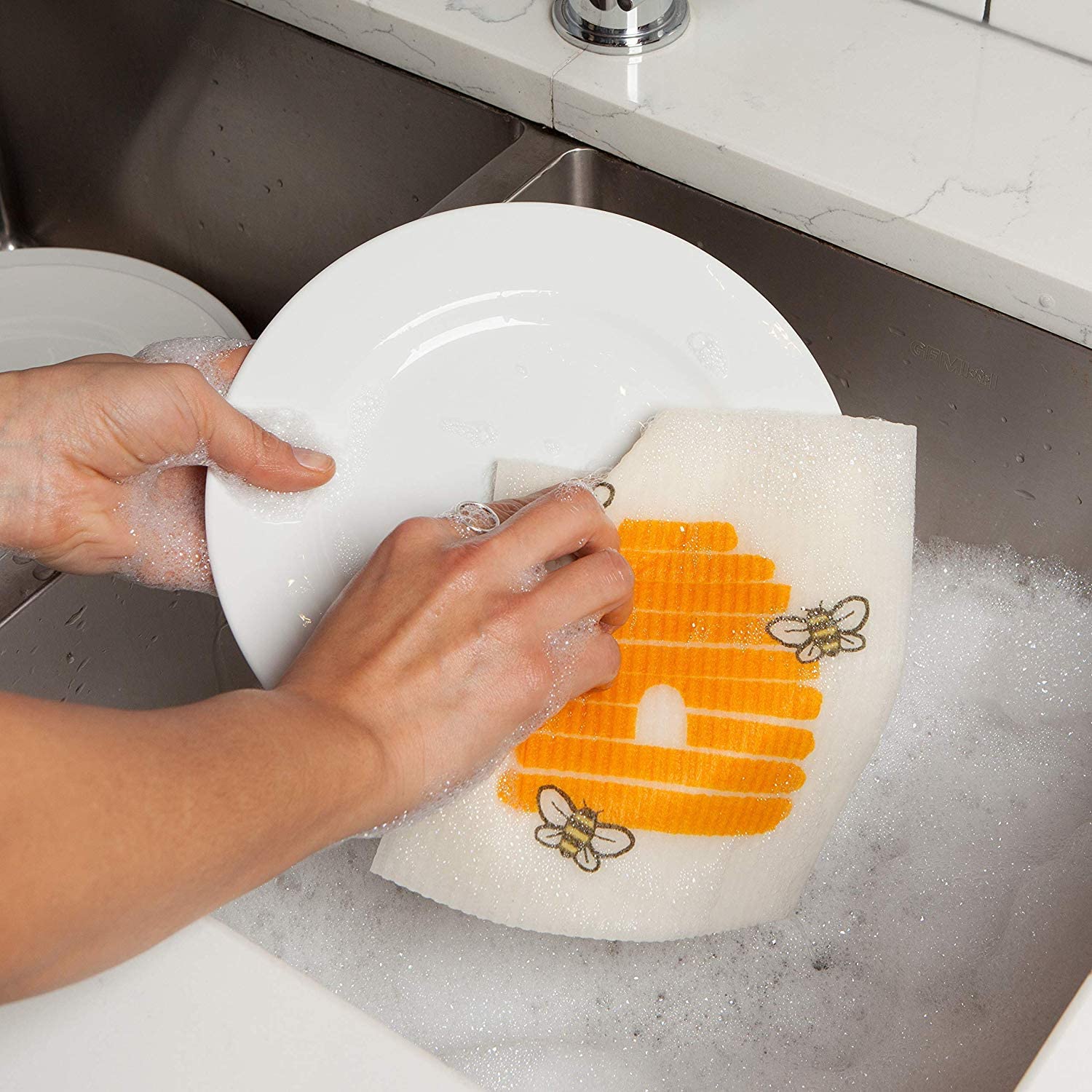 hands washing dishes with swedish dish cloth.