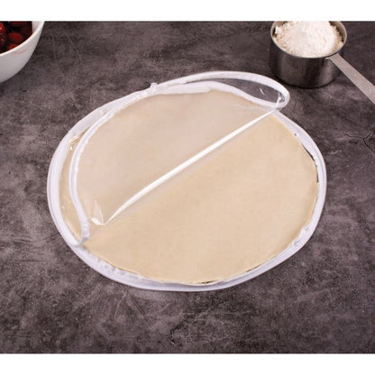 the 11 inch pie crust maker displayed with a pie crust on a gray surface next to a measuring cup