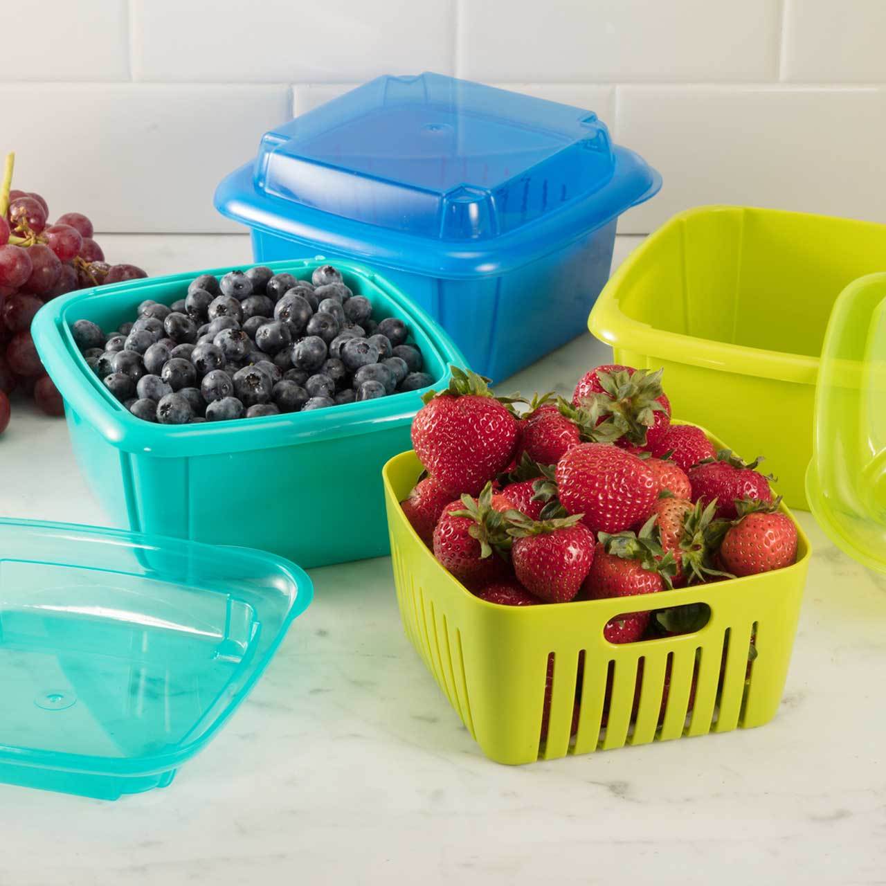four different colored berry boxes displayed on a mostly white countertop