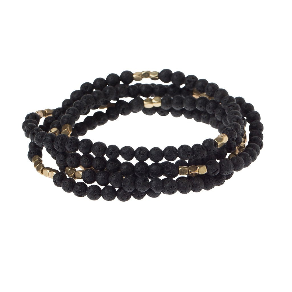 4.5 millimeter black lava beads interspersed with golden beads wrapped four times to form a bracelet, shown on a white background.