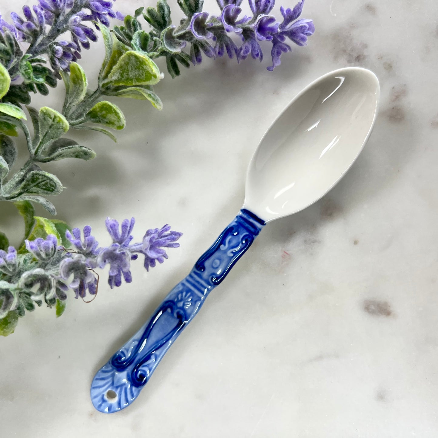 blue and white spoon with gothic pattern on handle.