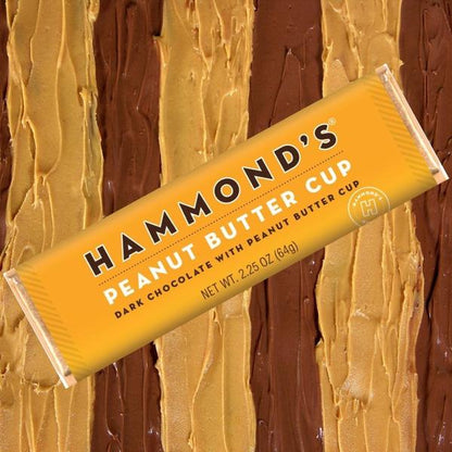 the peanut butter cup dark chocolate candy bar displayed on smeared peanut butter and smeared chocolate