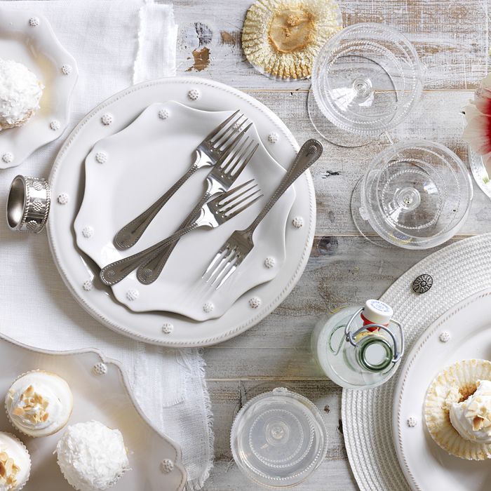table setting with dinner plate, salad plate, flatware and cups on a whitewashed wood table