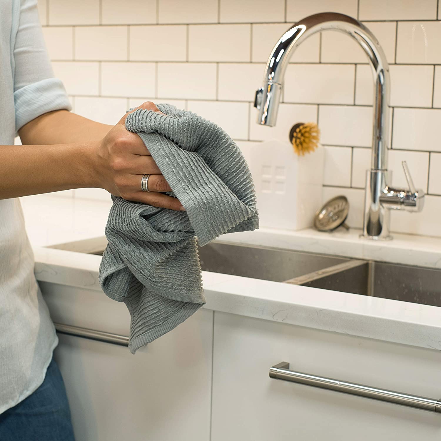 hands holding dishtowel at kitchen sink.