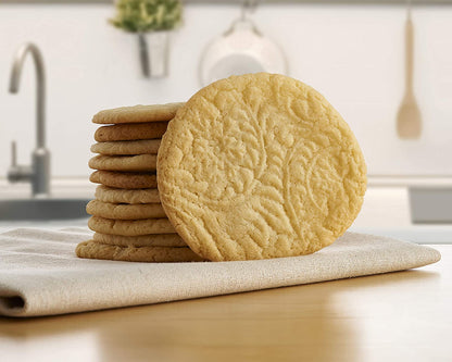 a stack of paisley designed cookies resting on a towel sitting on a wood countertop