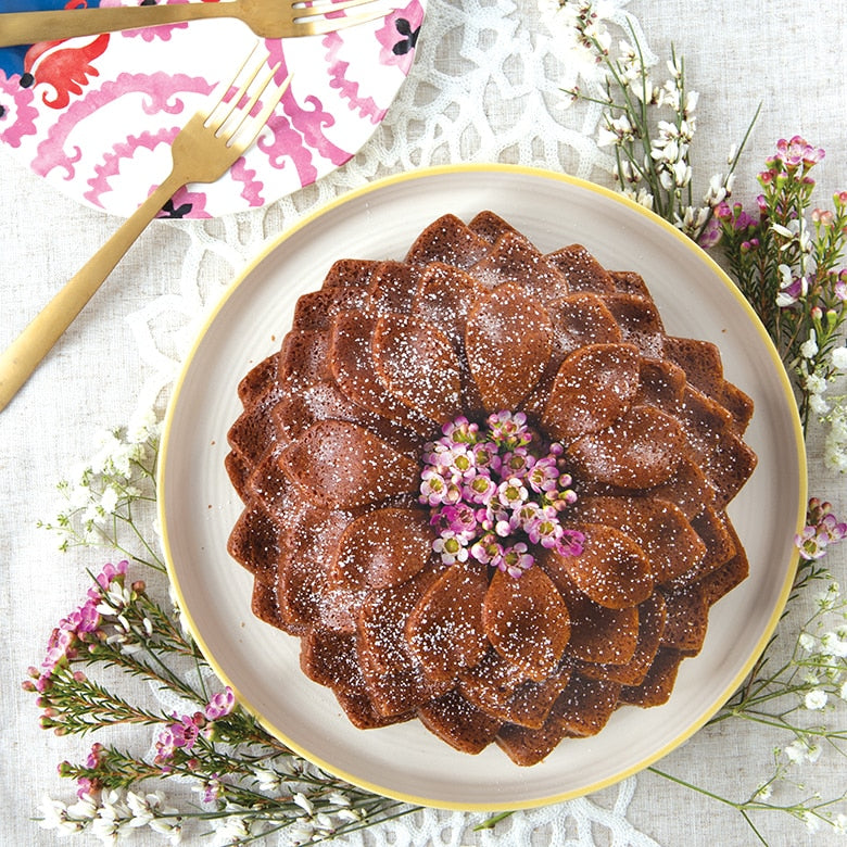 top view of chocolate flower shaped bundt cake with small flowers in the center.