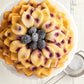 top view of flower shaped bundt cake with blackberries in the center.