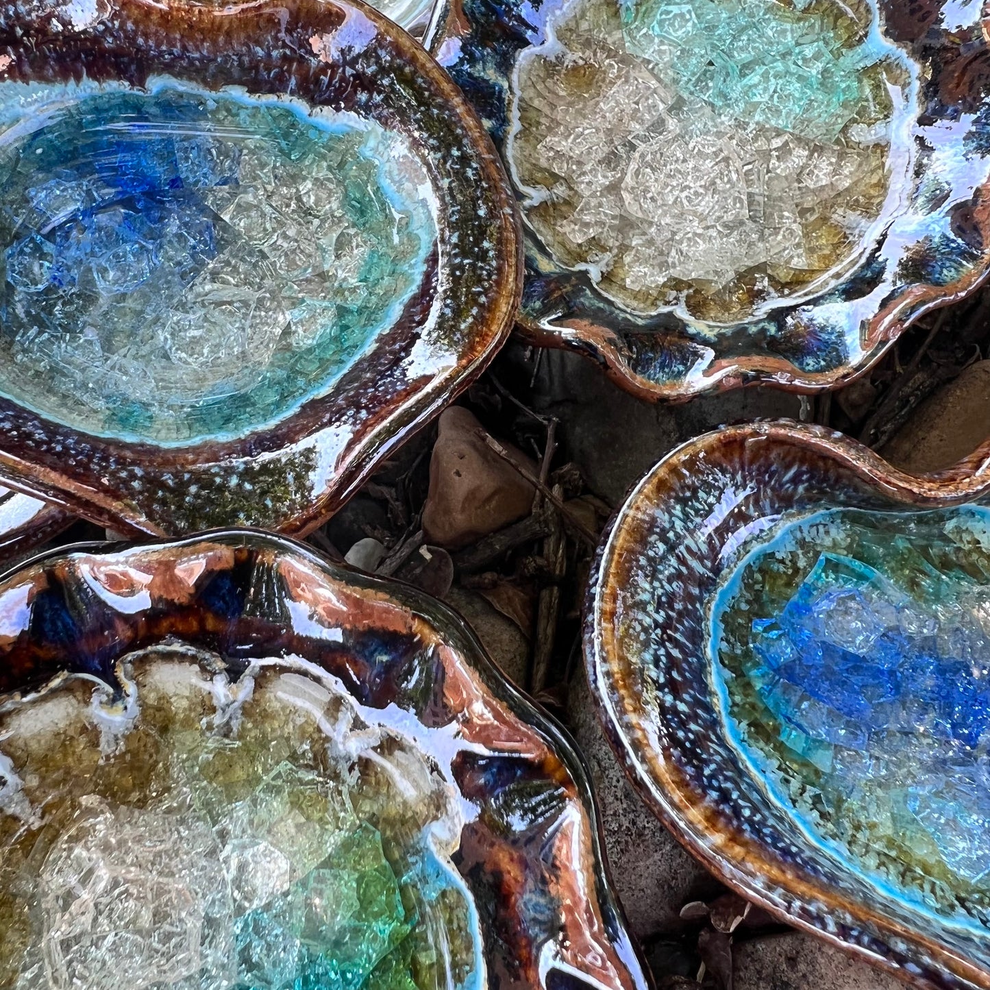 blues and browns heart and round crackled glass displayed on leaves and rocks