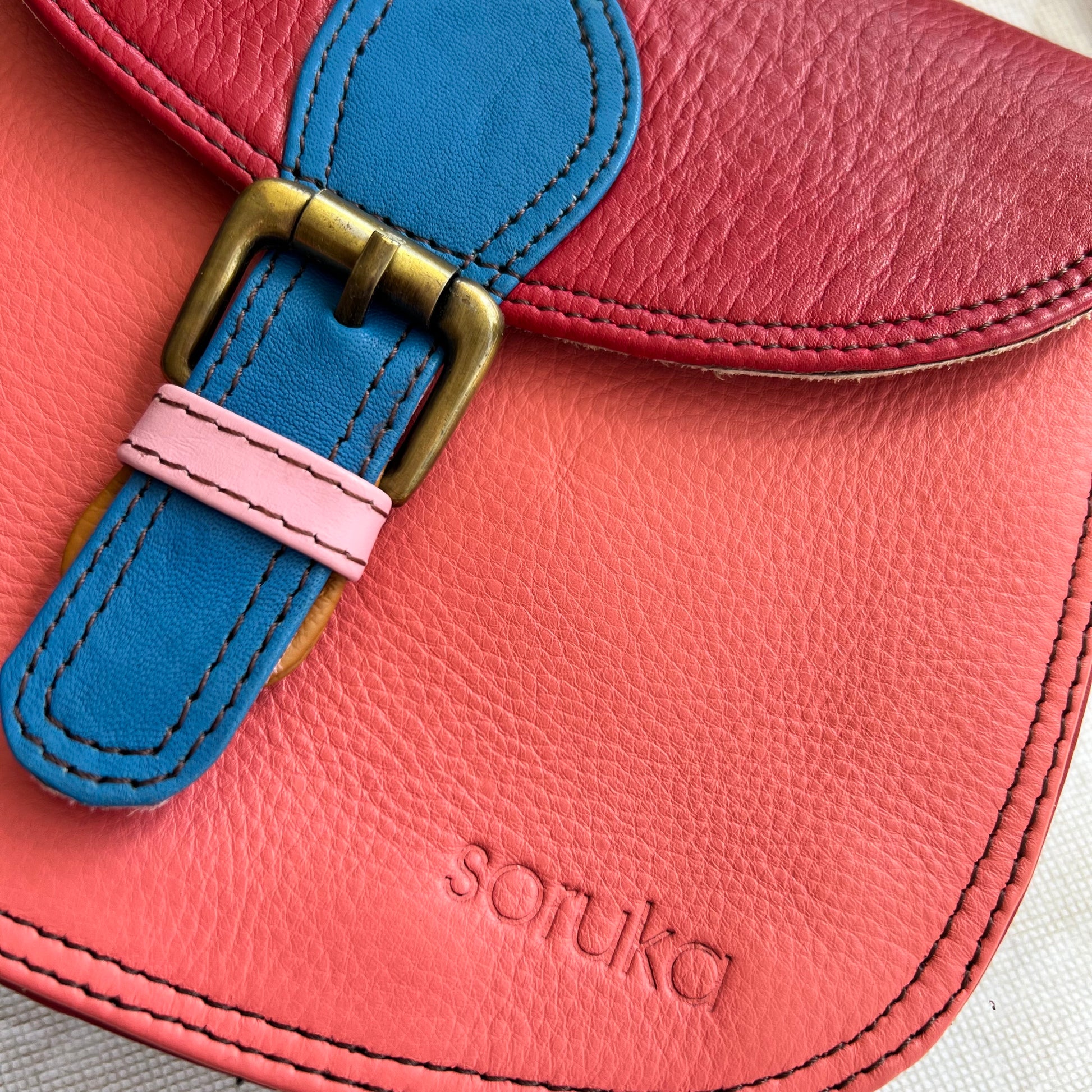 Close-up of buckle and stamped "soruka" logo.