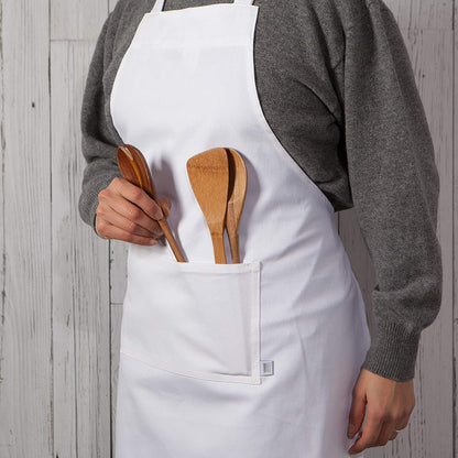 person wearing apron with wooden utensils in apron pocket.