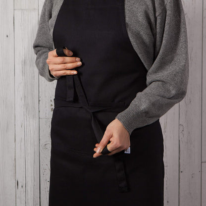 person wearing apron and tying it around waist.