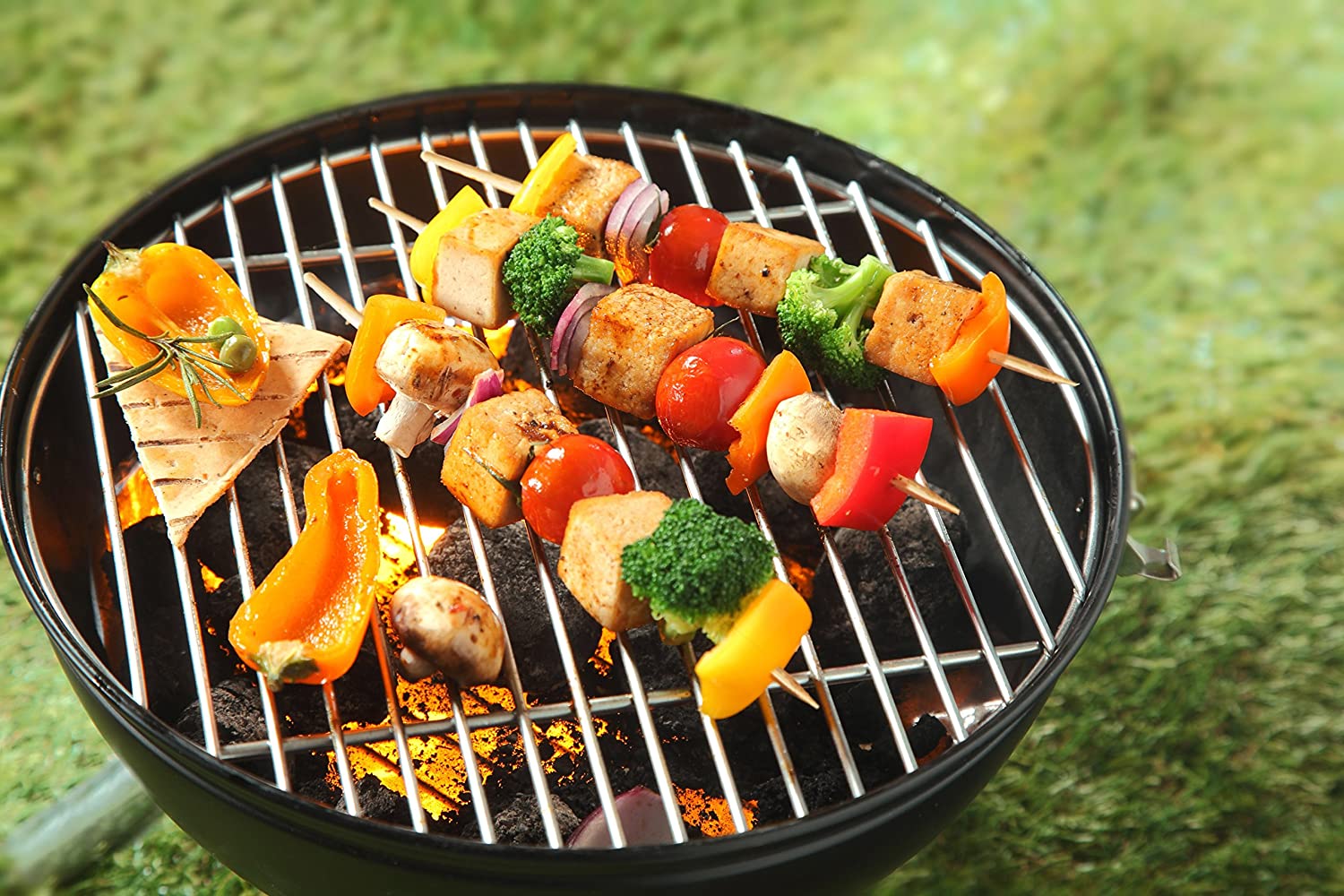 8 inch bamboo skewers being used to cook vegetables on a grill standing in the grass