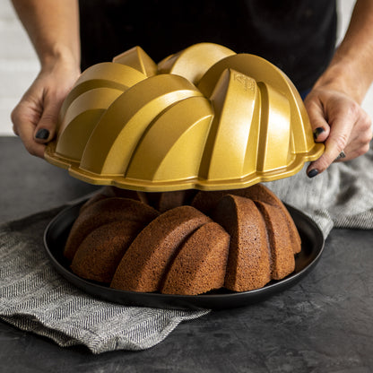 hands removing pan from braided bundt cake.