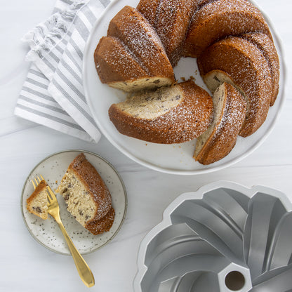 top view of braided bundt cake on tray with slice on plate with fork.