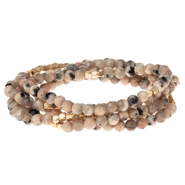 4.5 millimeter rhodonite beads interspersed with golden beads wrapped four times to form a bracelet, shown on a white background.
