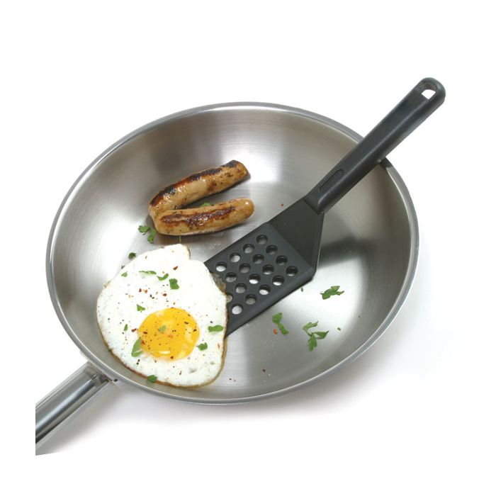 spatula in fry pan scooping up an egg.