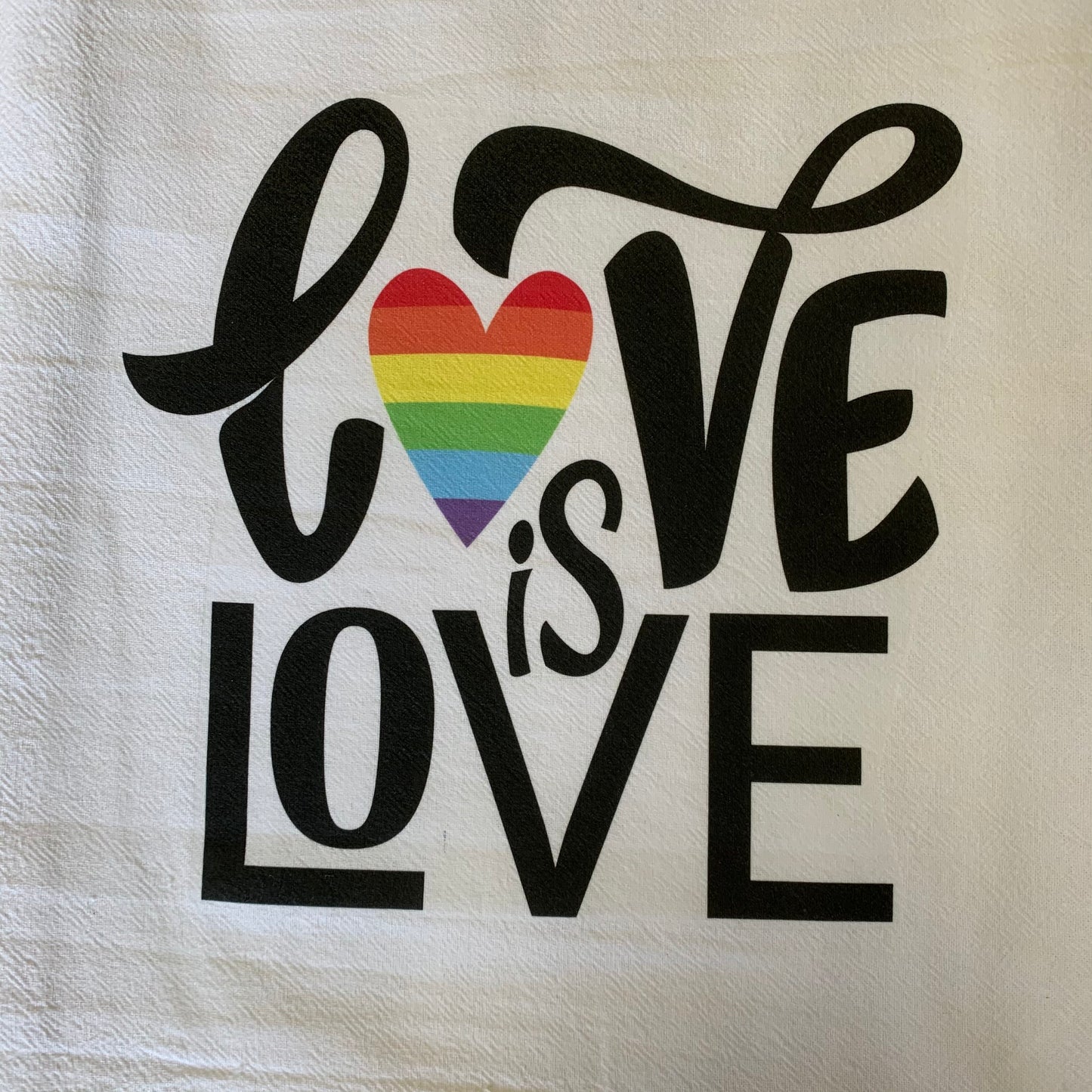 close up view of love is love flour sack towel