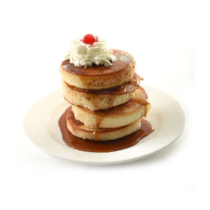 stack of round pancakes with whipped cream and a cherry on top.