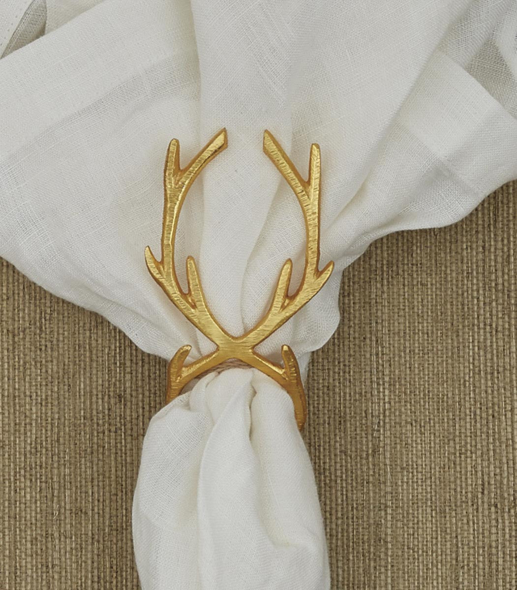golden napkin ring with antlers on top on a white napkin.