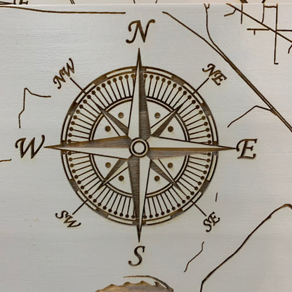 close up view of the compass rose on the grey burnt wood map of conway