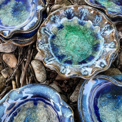 beautiful blues crackled glass little dish stacked on a bed of leaves and rocks