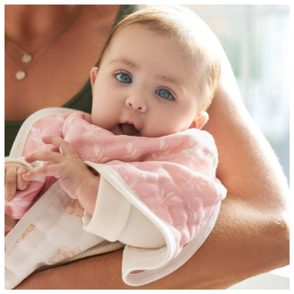 baby wearing cotton muslin burpy bib being held by a woman