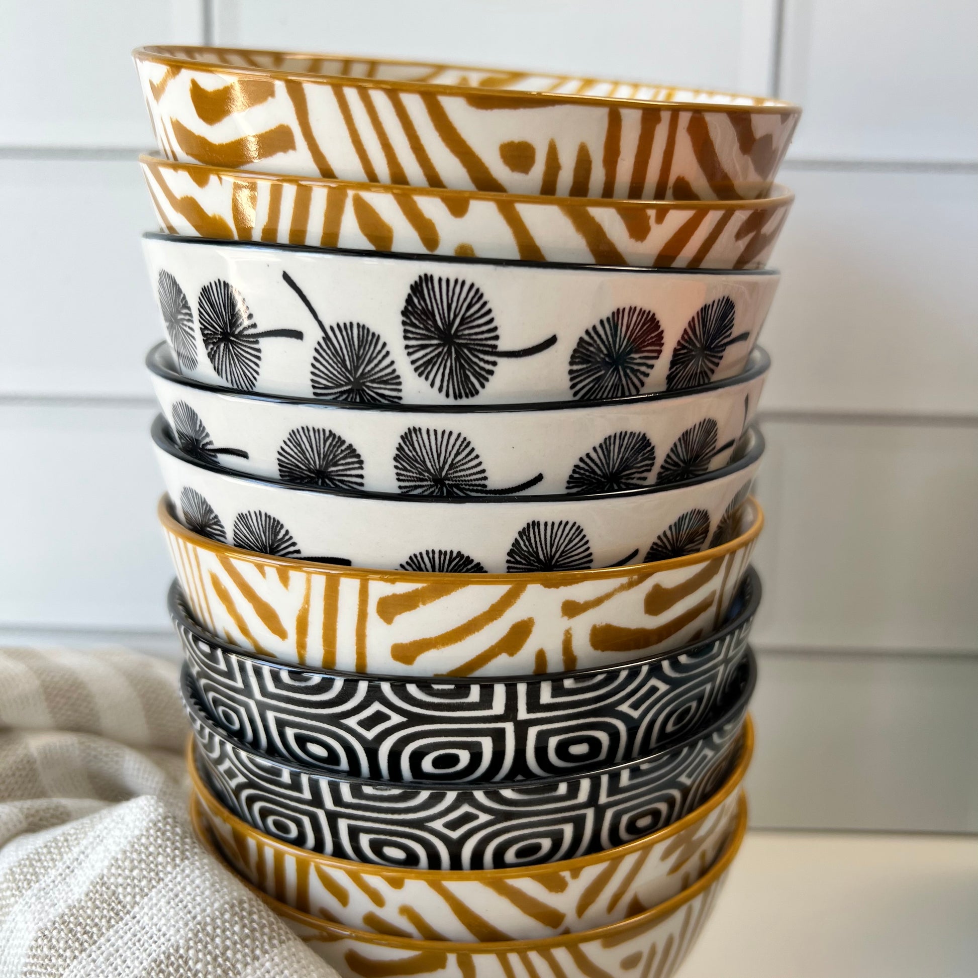 single stack of assorted bowls on a countertop with a dishtowel.
