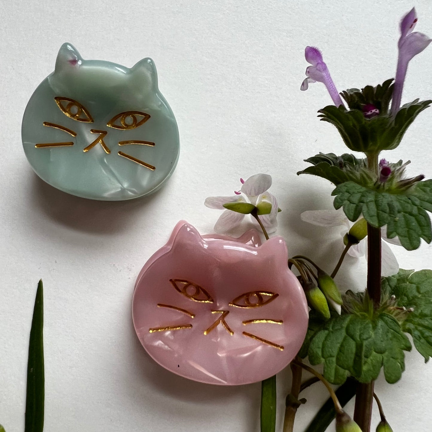 close-up of pink and green cat face clip.