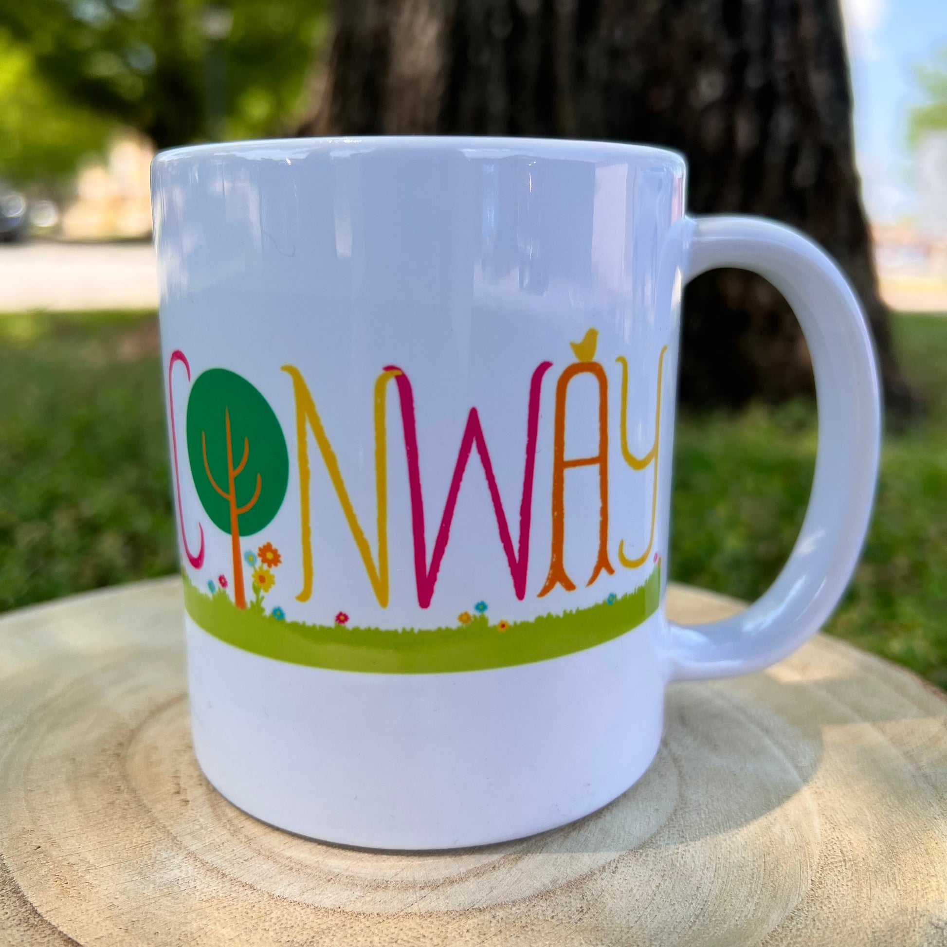 white ceramic mug with "conway" text surrounded with park greenery.