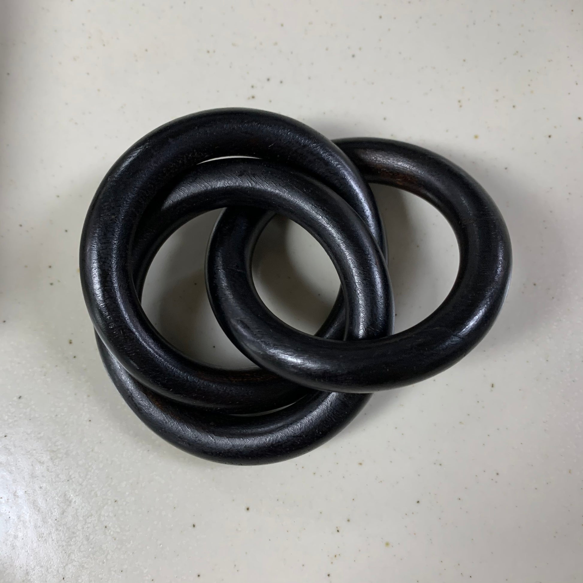 black napkin ring on off-white background.