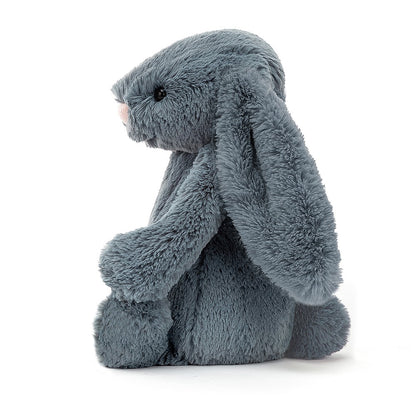 side view of dusty blue bashful bunny on a white background