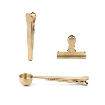 three different brass clips on a white background