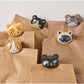 six brown bags with cat bag clips on each one against a white background