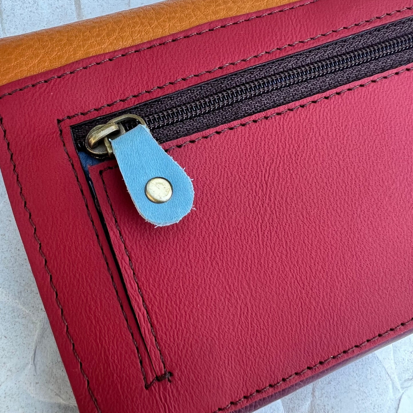 close up view of the zipper on the maroon and mango secret clutch