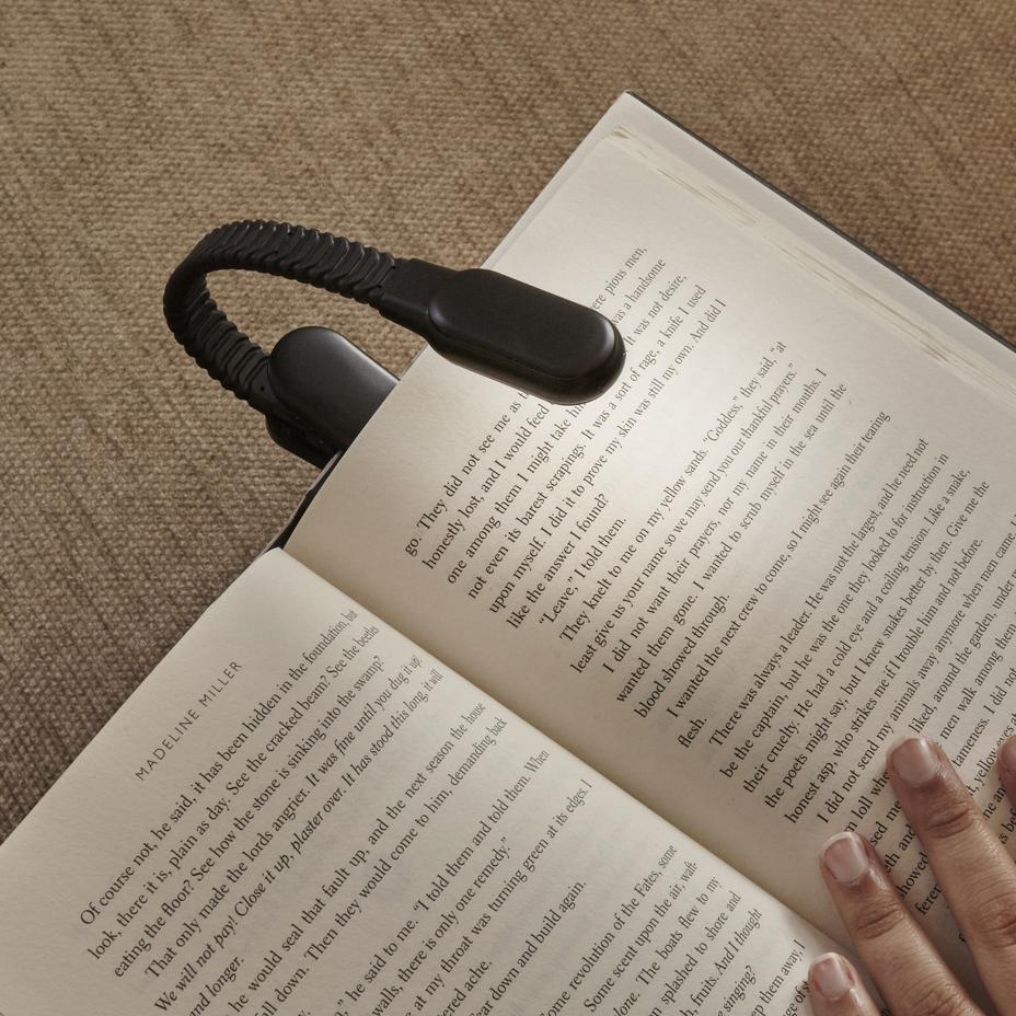 illustration a the rechargeable booklight with a book against a tan background 