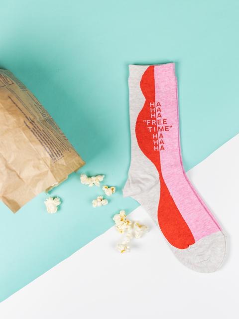 free time crew socks laying on a turquoise and white background with a bag of popcorn
