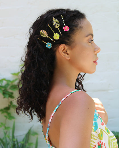side view of a woman modeling all 5 palm palms floral enamel bobby pins is her hair while standing outside