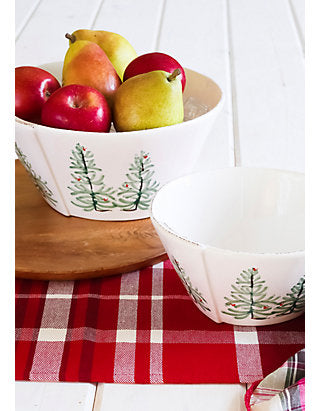 2 lastra holiday serving bowls arranged on a table with a red plaid runner, one bowl is filed with fruit.