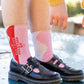 a woman wearing free time crew socks standing on a table outside