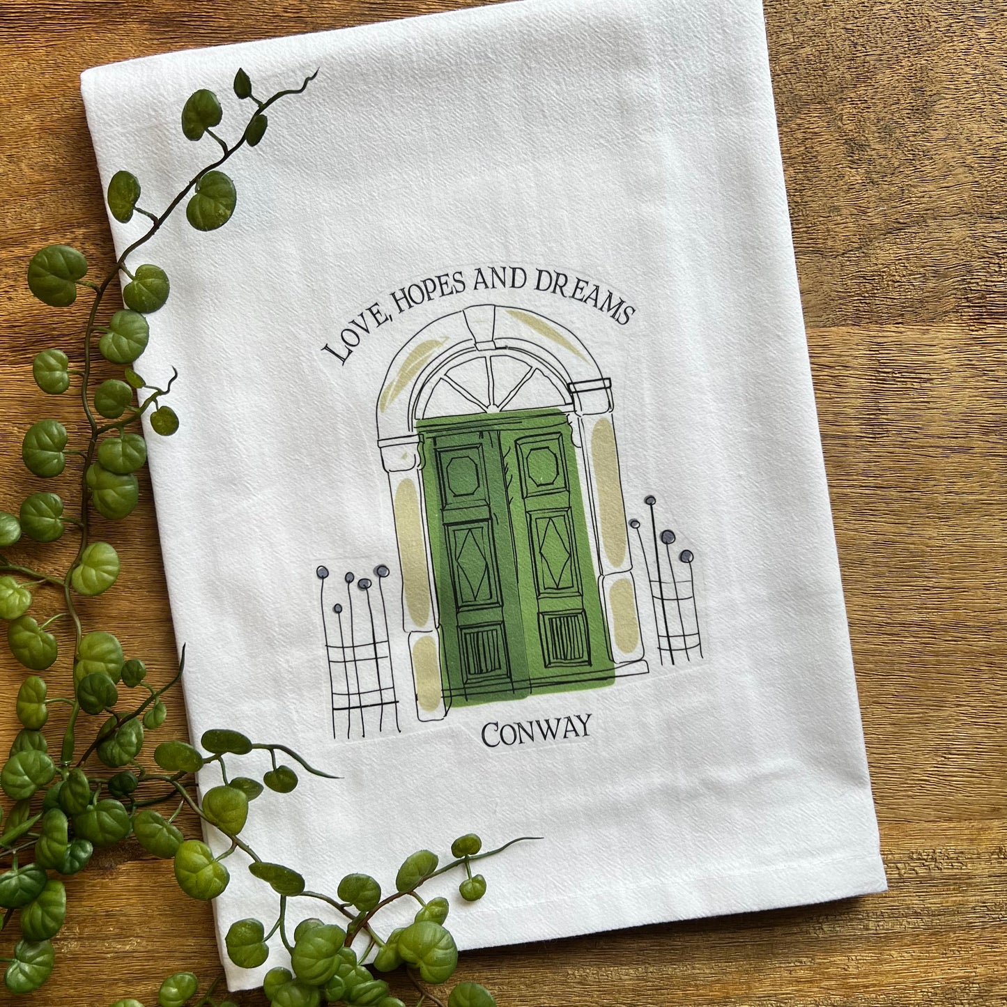 white towel with green front door design and "love, hopes and dreams" across the top and "conway along the bottom.