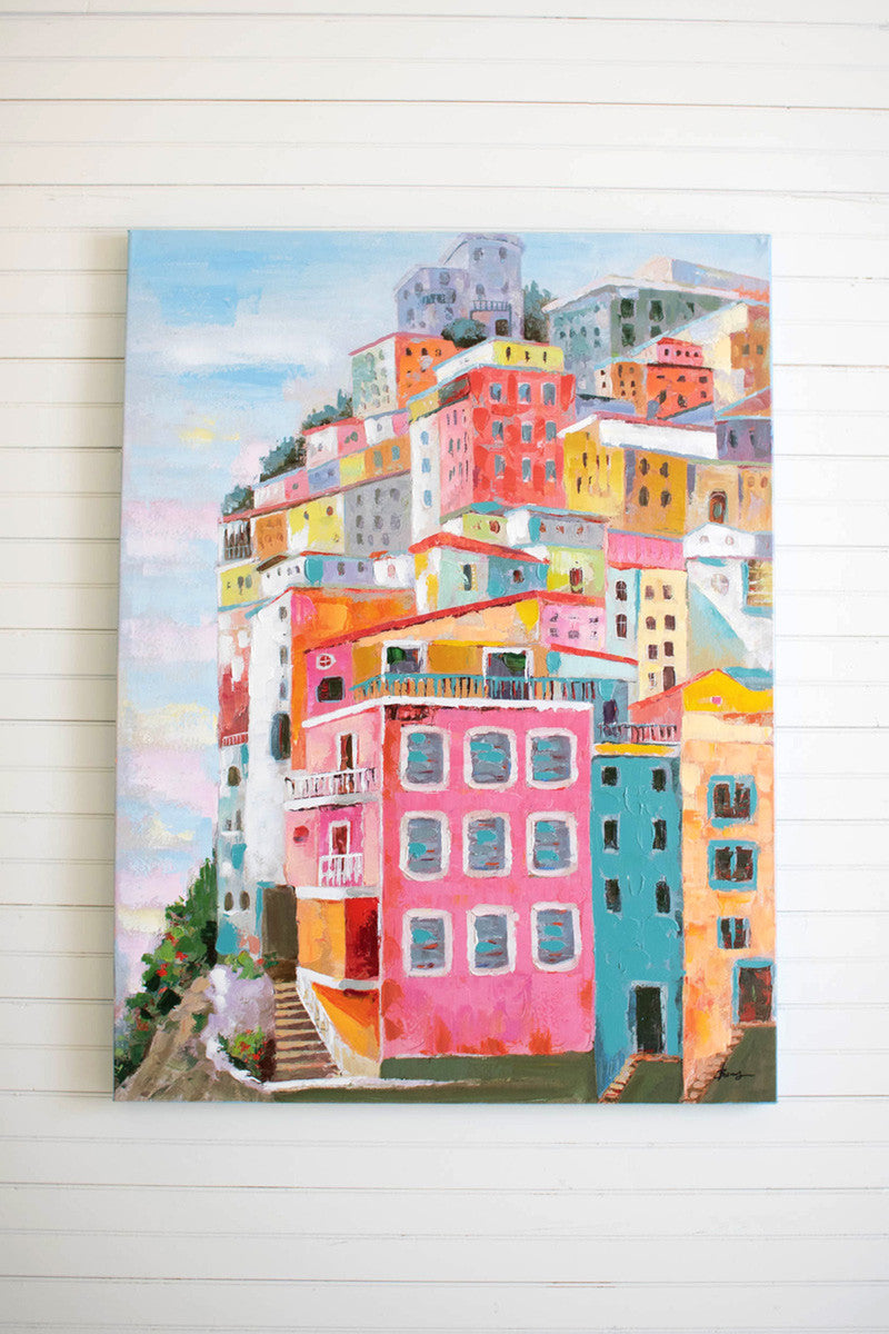 colorful houses oil panting hanging on a white slat wall